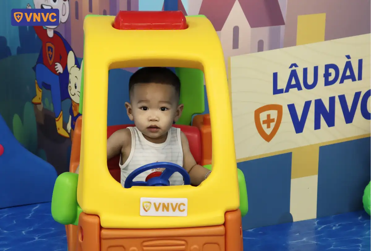 bé ngồi trong xe đồ chơi