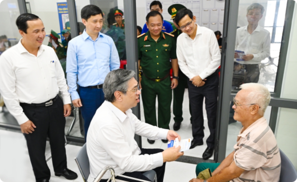 các cán bộ ghé thăm cụ ông được tiêm phòng miễn phí