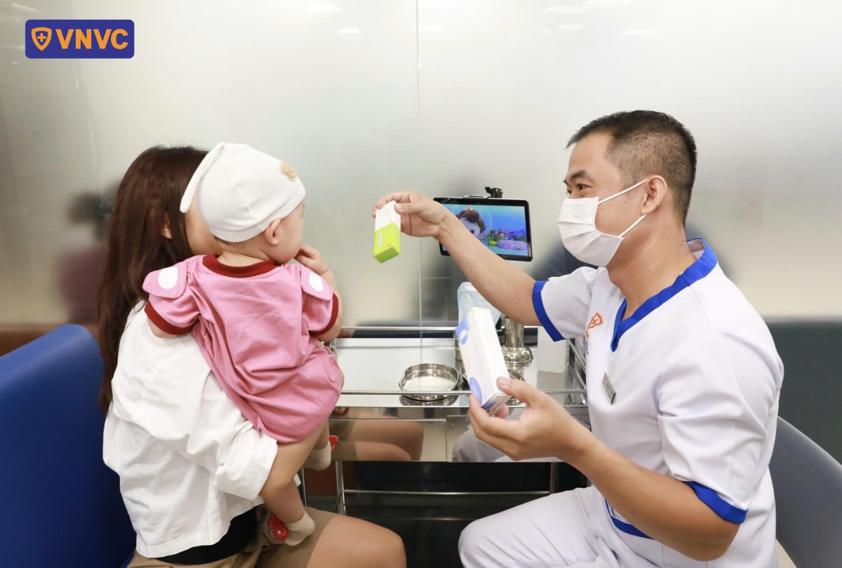điều dưỡng nam tiêm vắc xin cho bé