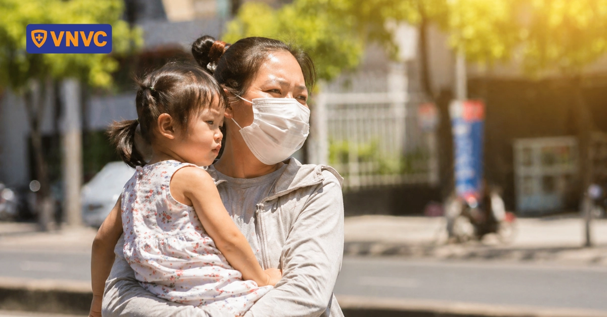 mẹ bế em bé dưới nắng