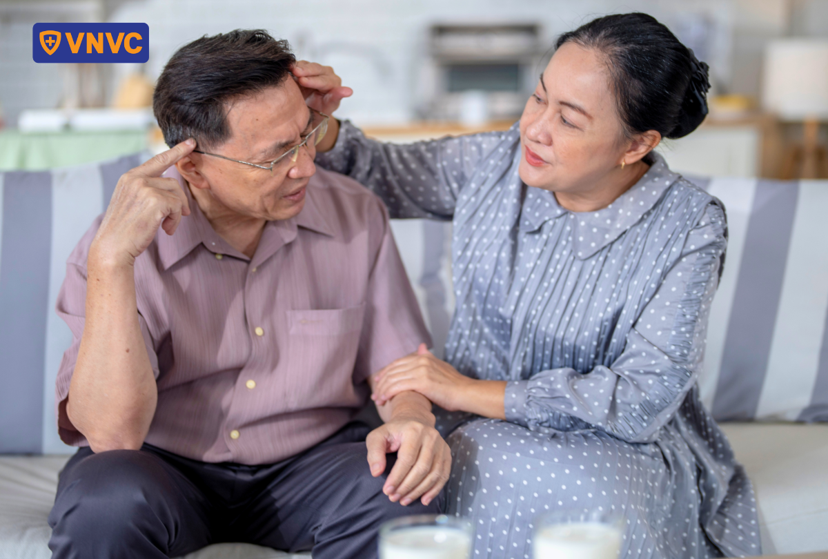 người lớn tuổi ngồi chạm tay vào trán