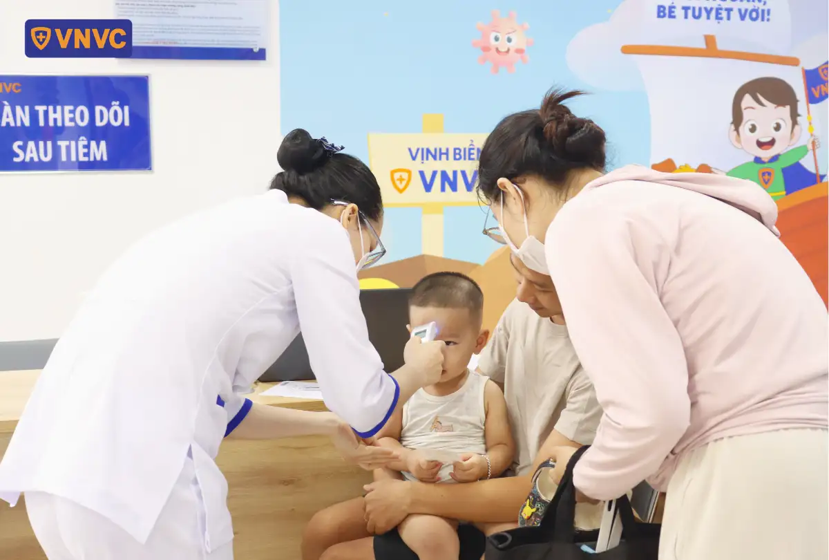 nhân viên đo nhiệt độ cho bé