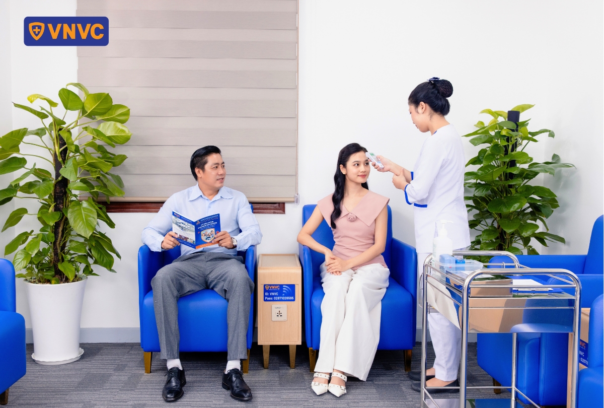 nhân viên y tế đo nhiệt độ cho khách