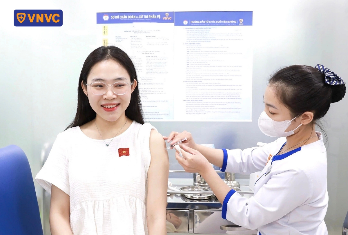 nhân viên y tế tiêm phòng cho khách nữ