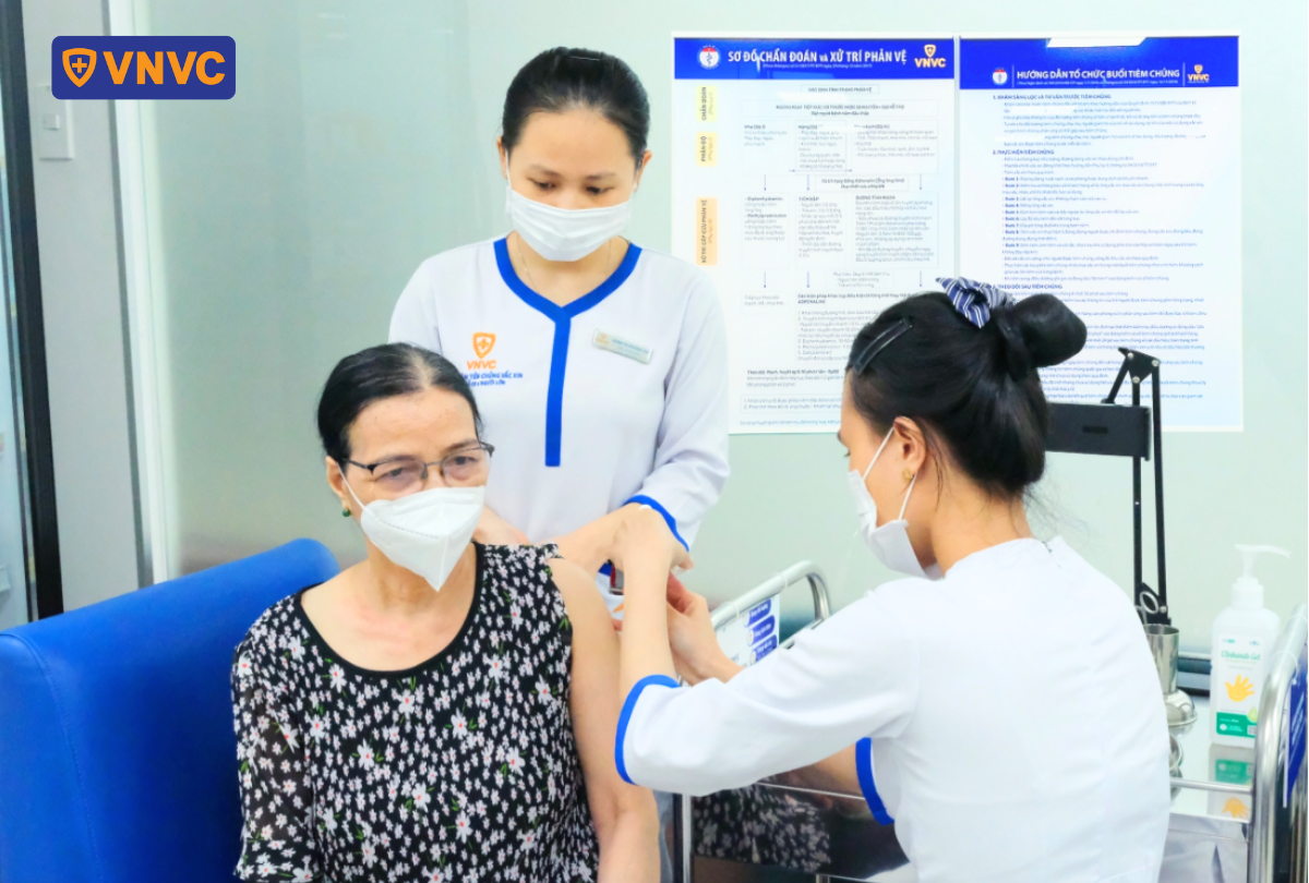 nhân viên y tế tiêm vắc xin cho người già