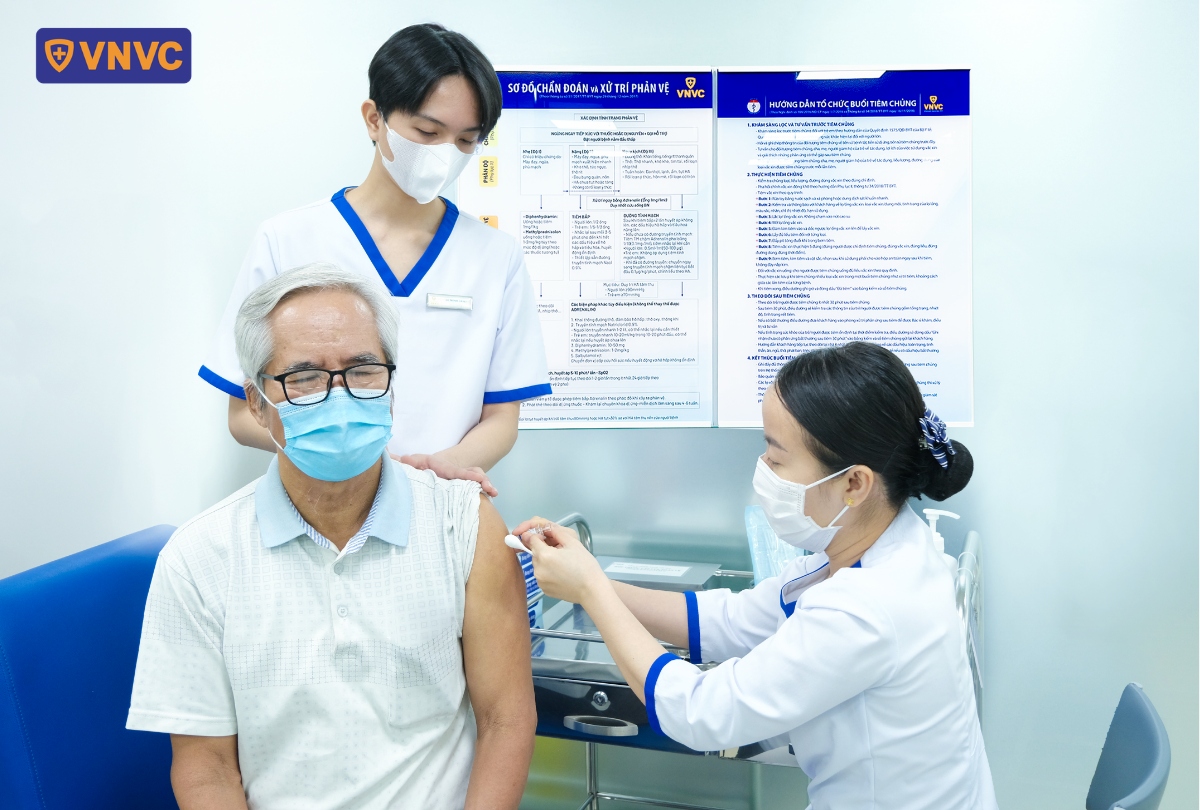 điều dưỡng tiêm vắc xin cho cụ ông