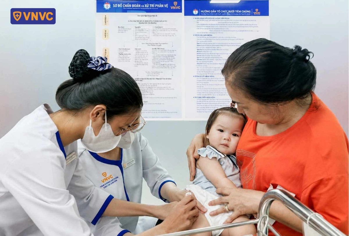 bà bế bé tiêm vắc xin