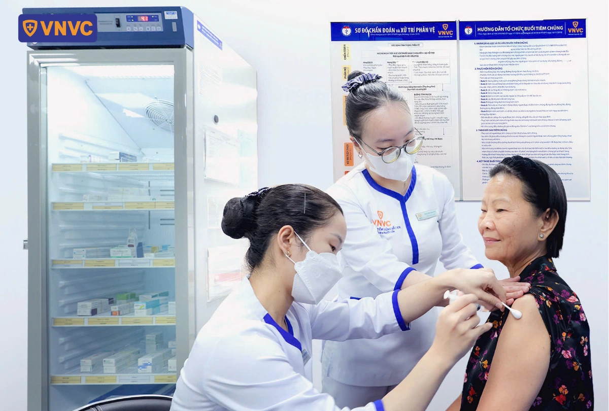 nhân viên y tế tiêm cho bà lão