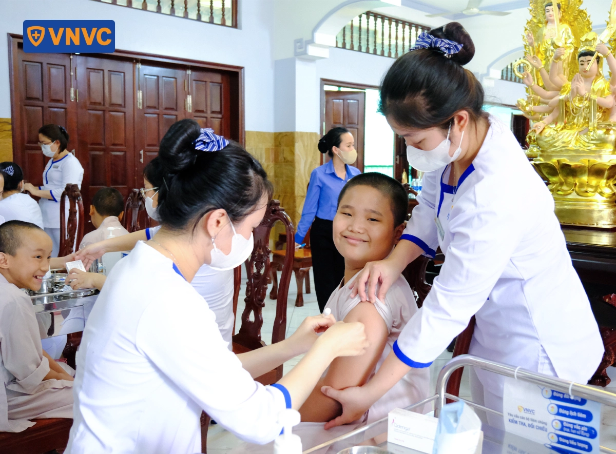 điều dưỡng tiêm vắc xin cho chú tiểu