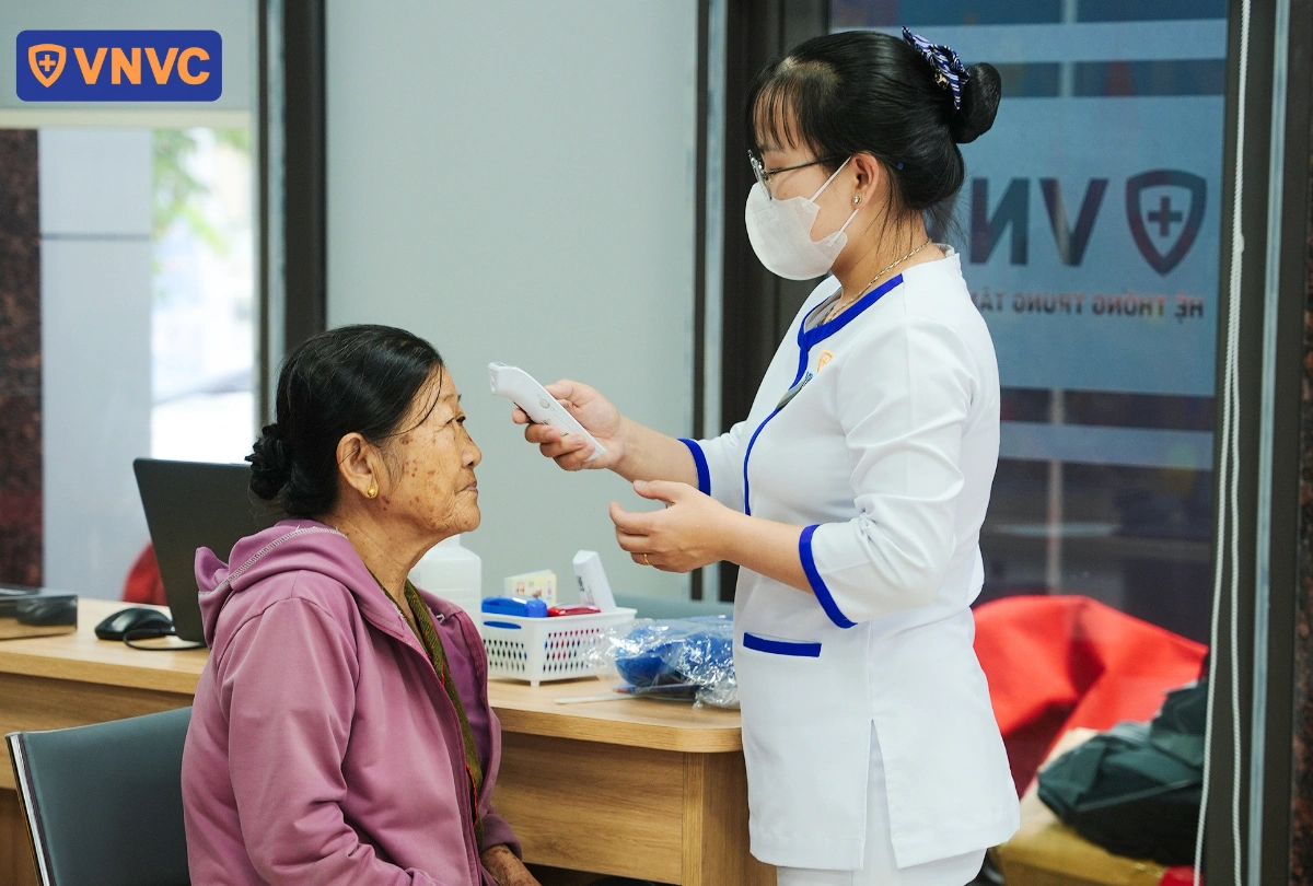 đo nhiệt độ cho người trung niên trước tiêm