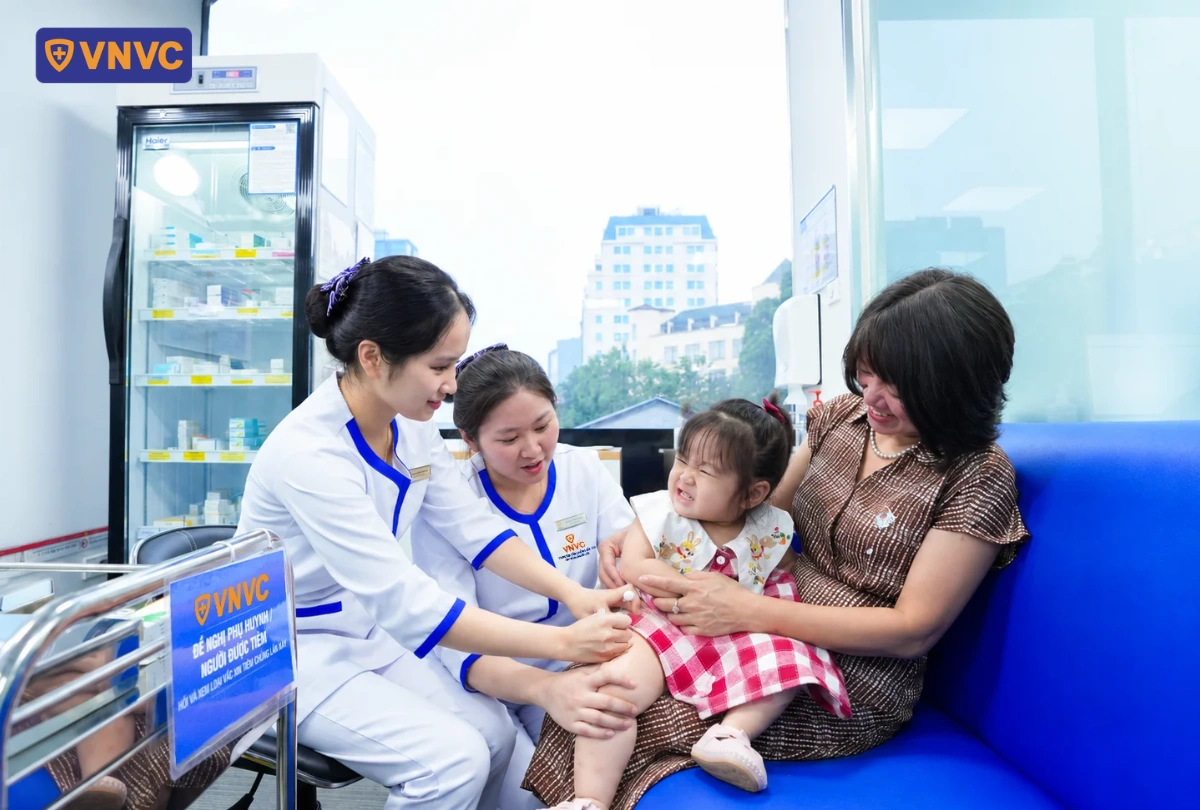 em bé đi tiêm vắc xin tay chân miệng