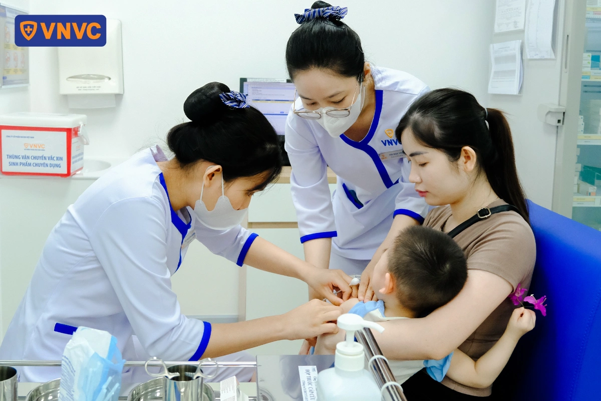mẹ ẵm em bé đi tiêm vacxin