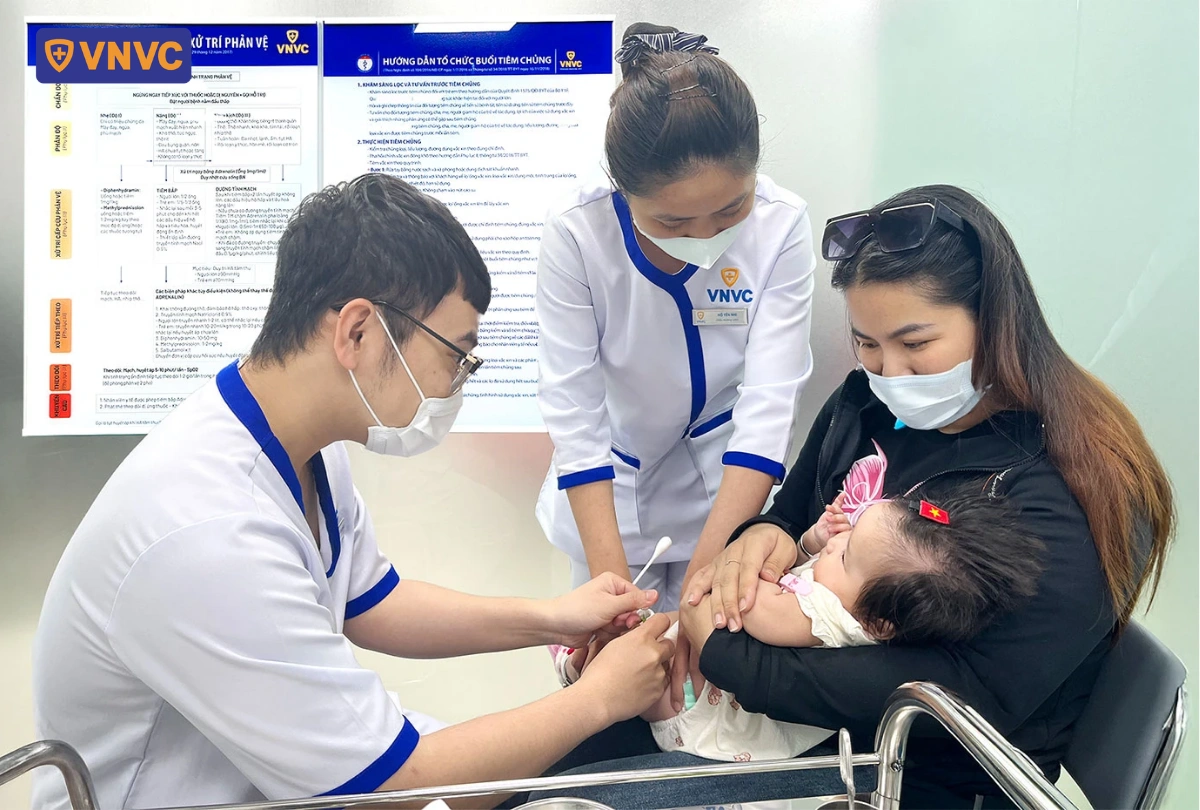 nhân viên y tế tiêm vắc xin cho em bé