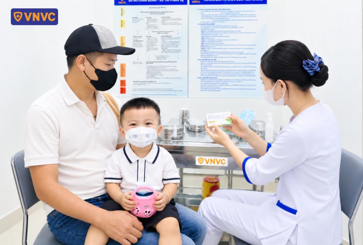 ba đưa con trai đi tiêm vắc xin tay chân miệng tại vnvc