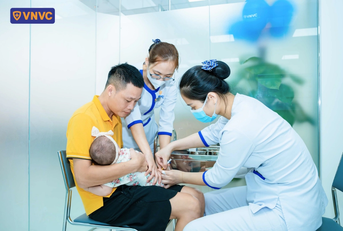 bố bế con đi tiêm ở vnvc