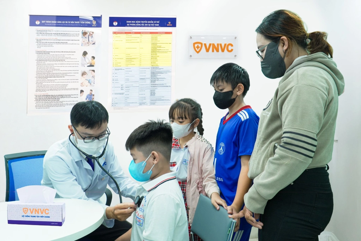 male doctor examining young boy with stethoscope at clinic