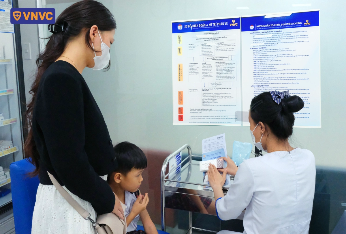mẹ đưa con đi tiêm vắc xin